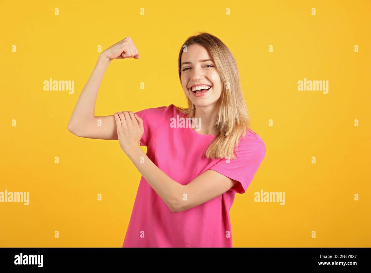 Eine starke Frau als Symbol der Macht eines Mädchens auf gelbem Hintergrund. Konzept vom 8. März Stockfoto