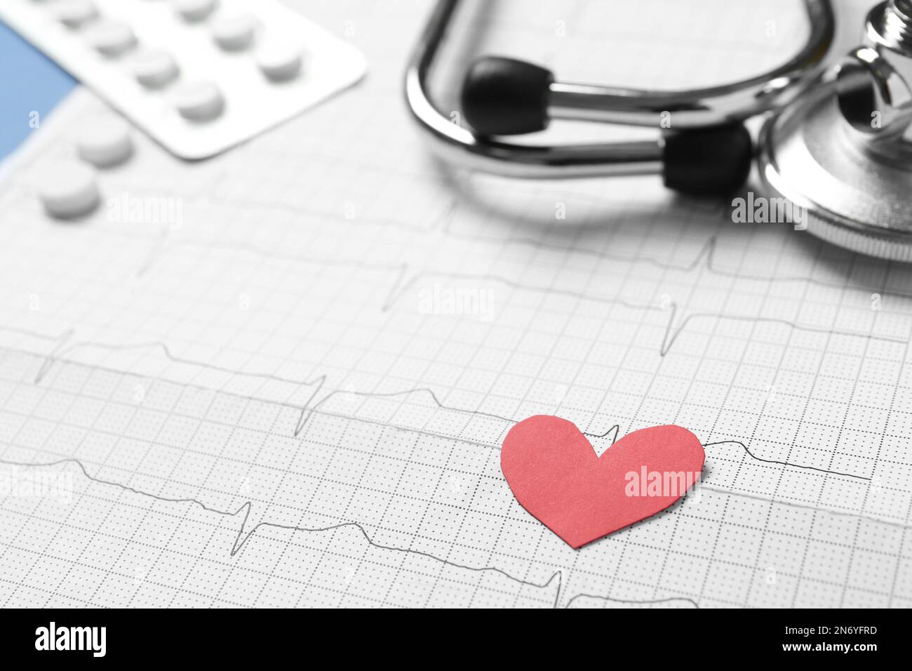 Rotes Papierherz, Pillen und Stethoskop im Kardiogramm, Nahaufnahme Stockfoto