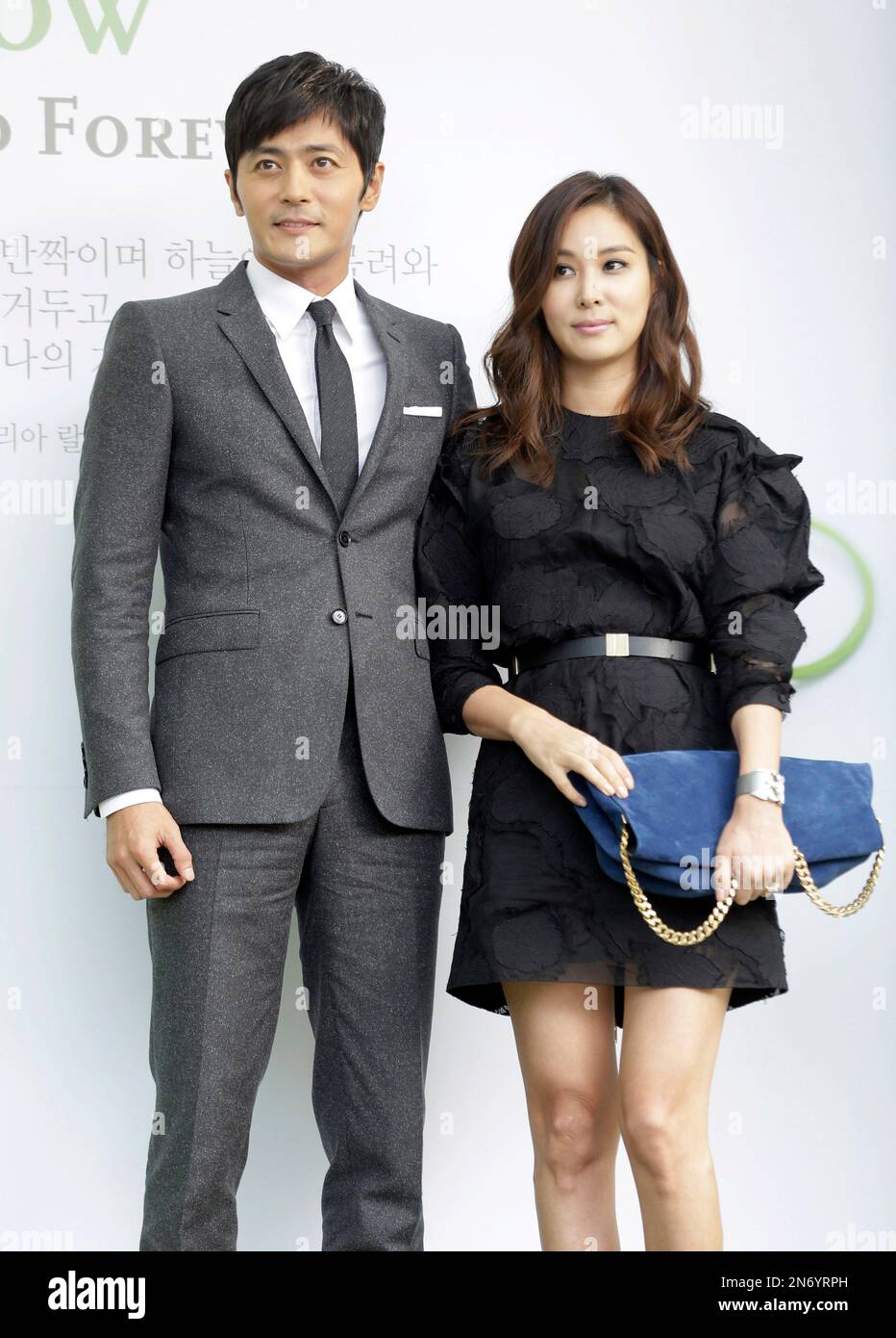 South Korean actor Jang Dong-gun, left, and his wife and actress Ko So-young pose for the media upon their arrival for South Korean actor Lee Byung-hun and his bride and actress Rhee Min-jung's wedding ceremony in Seoul, South Korea, Saturday, Aug. 10, 2013. (AP Photo/Lee Jin-man) Stockfoto