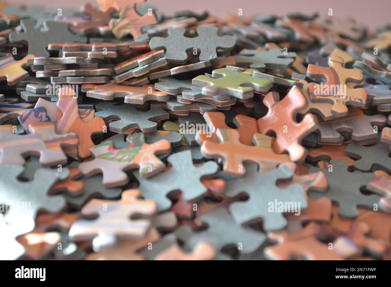 Puzzleteile in Einem Stapel Alle zusammen – Sonnenlicht auf den Puzzleteilen – Großbritannien Stockfoto
