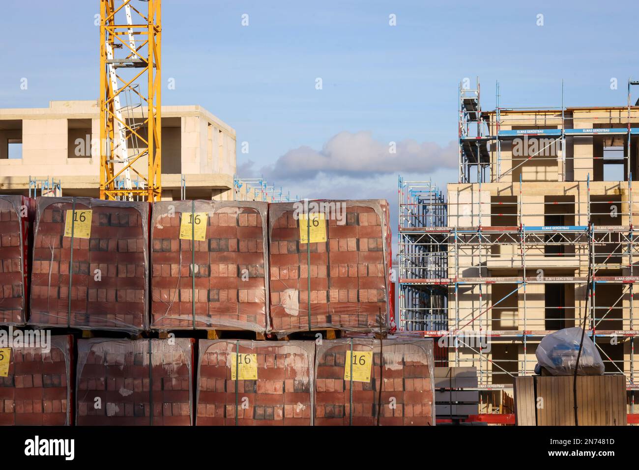 Bedburg, Nordrhein-Westfalen, Deutschland – Baumaterial, auf Paletten verpackte Klinkersteine, Wohnungsbau, Neubau von Mehrfamilienhäusern Stockfoto