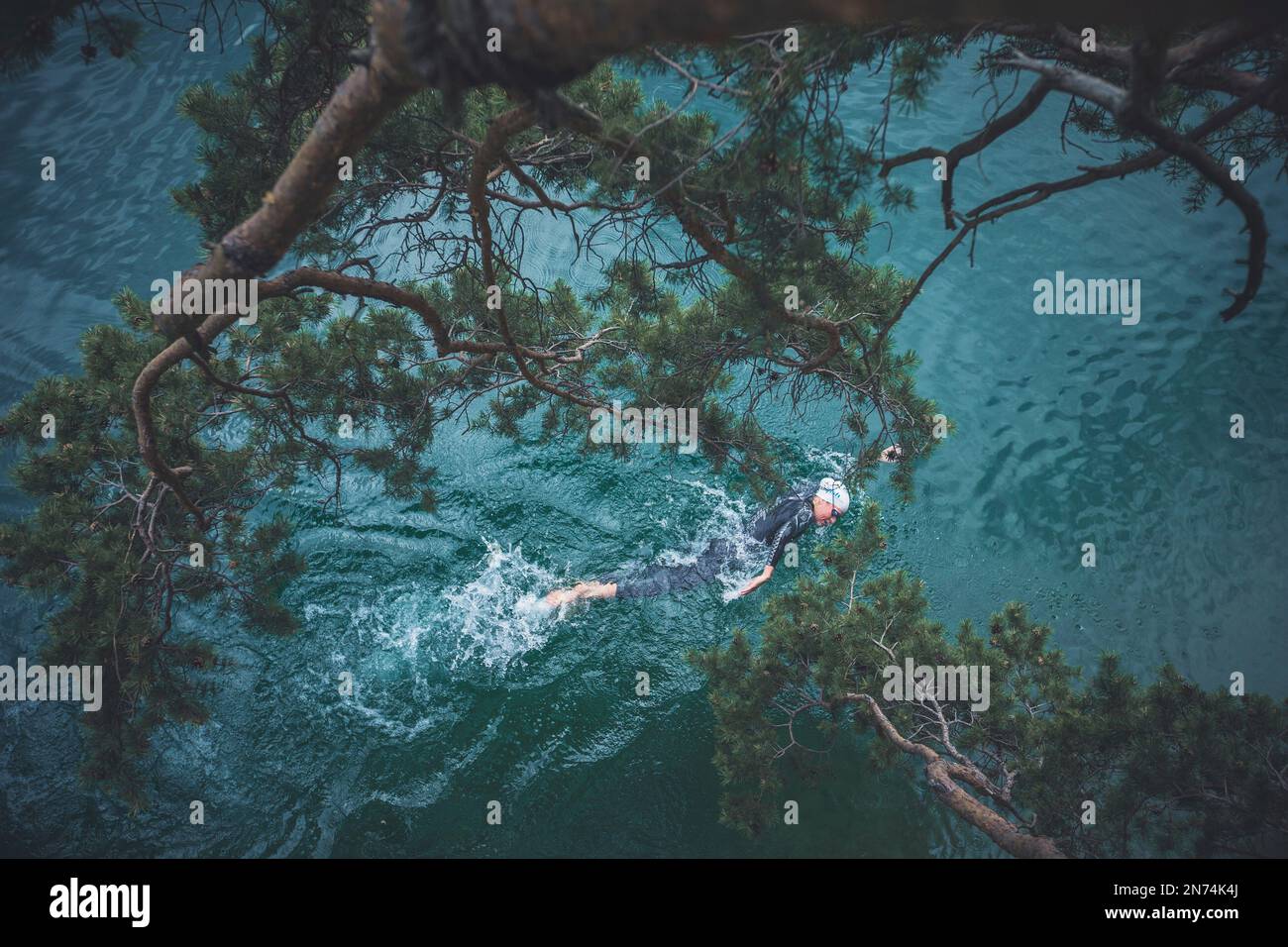 Professioneller Triathlet Schwimmen, Training in einem klaren Bergsee in Allgäu, Alatsee, Bayern, Deutschland Stockfoto