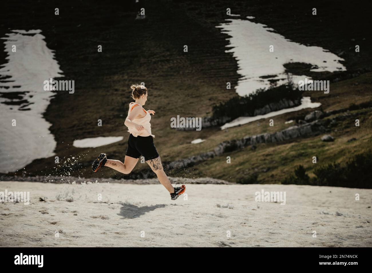 Eine Frau auf einem großartigen Pfad, die durch das Schachenhaus von König Ludwig in den Wettersteinbergen in Bayern läuft. Stockfoto