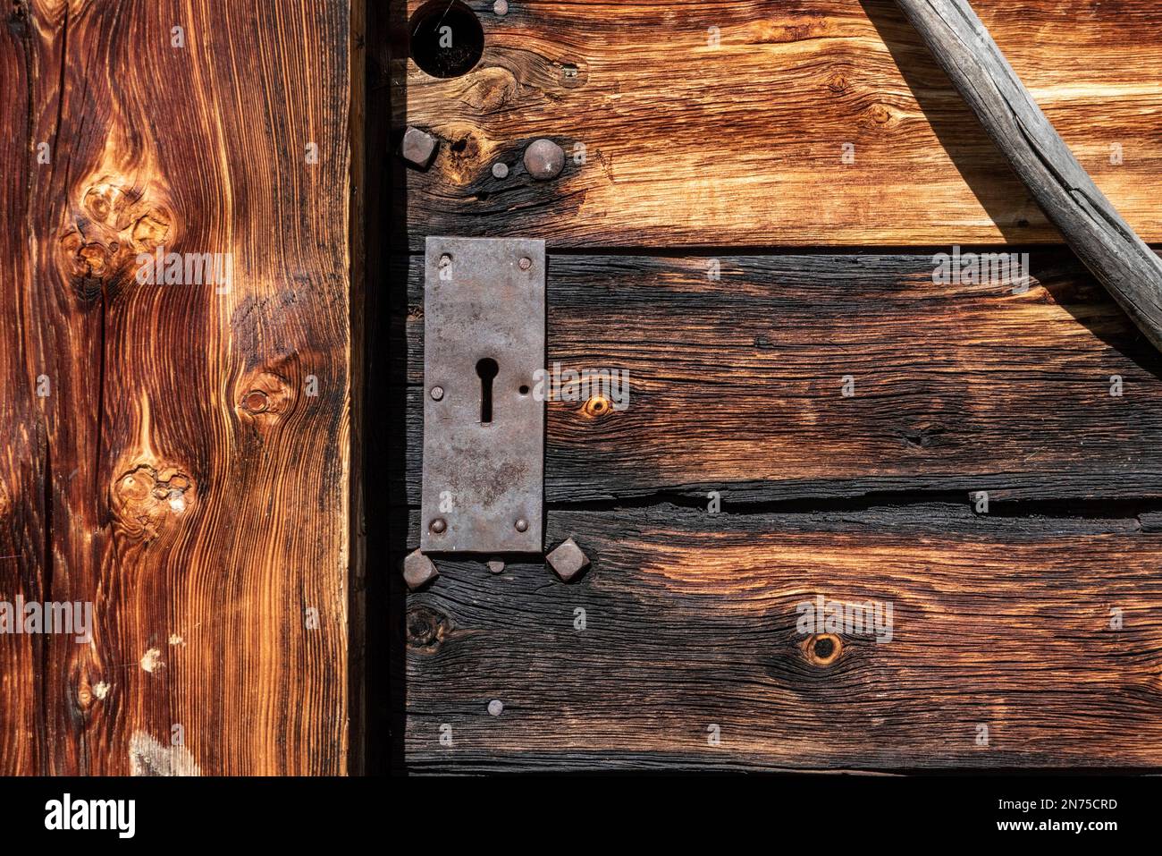 Nahaufnahme einer Holztür einer typischen Almhütte, den Dolomitenalpen in Südtirol Stockfoto