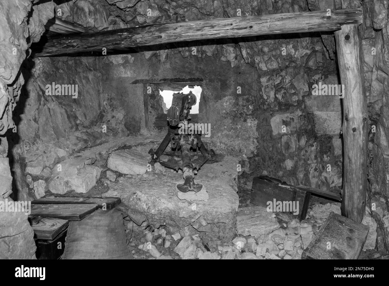 Ein Schlupfloch und ein altes Maschinengewehr in einem Tunnel des Mount Lagazuoi in den Dolomitalpen, gebaut während der Ersten Welt, Autonomes Pronvince von Südtirol Stockfoto