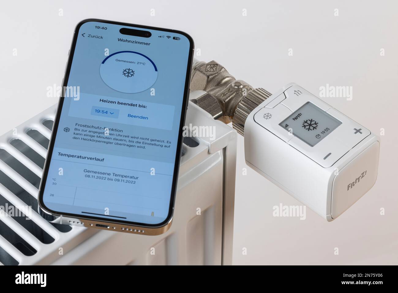 Apple iPhone, Display, FRITZ! Smart Home App, Kühler,  WLAN-Heizkörperthermostat FRITZ! DECT 302, Display zeigt  Schneeflocken-Symbol, Frostschutz ca. ö°C., weißer Hintergrund, Symbolbild,  Smartphone für Heizungssteuerung, Smart Home, Netzwerk, digital ...