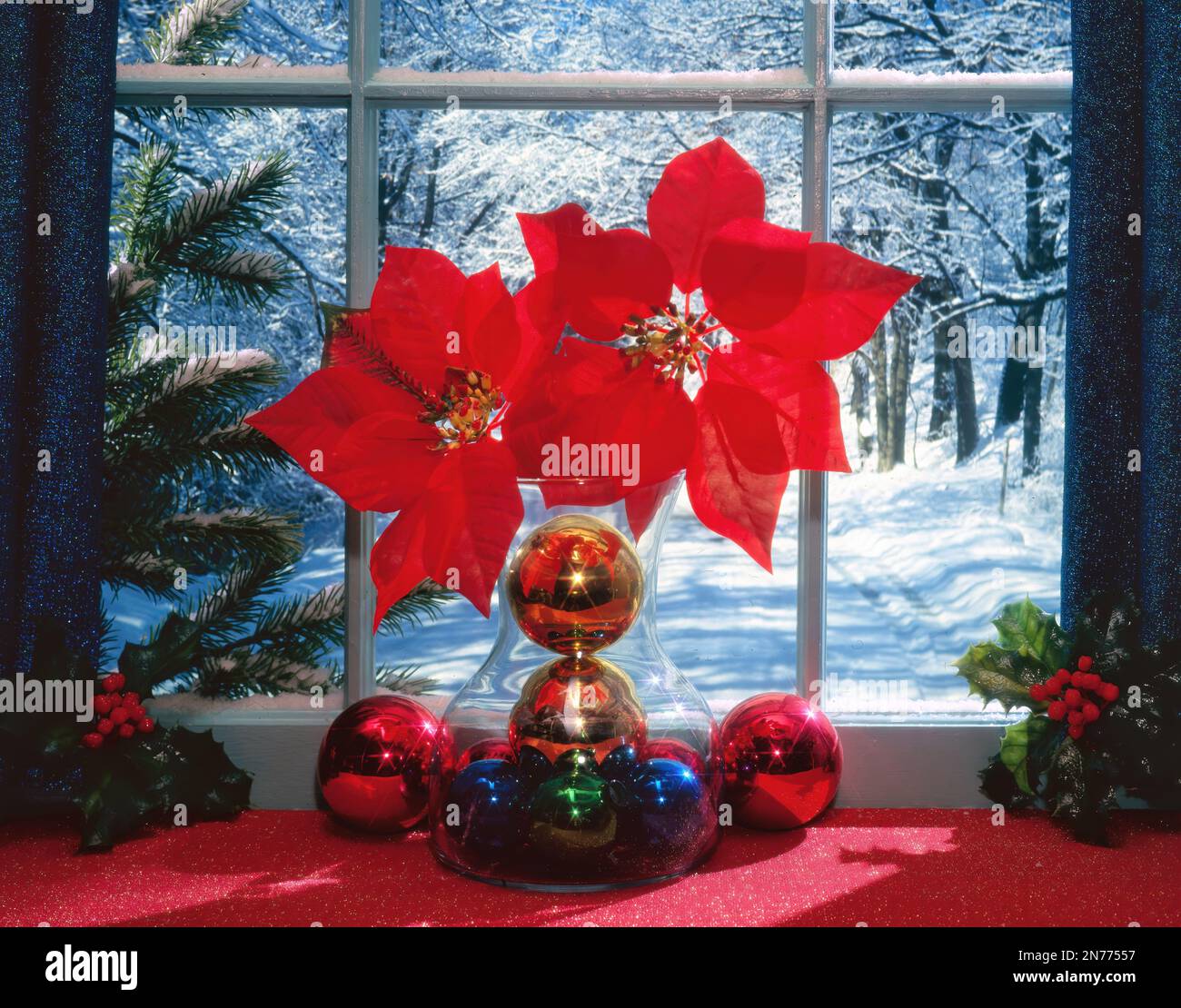 Weihnachtsdekorationen vor einem Fenster mit schneebedeckten Hintergrund. Stockfoto