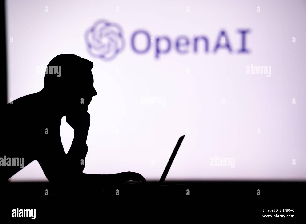 GROSSBRITANNIEN, LONDON. 30. JANUAR 2023: The Future of Technology in the Palm of His Hand: Silhouette of man with AI Software Logo Stockfoto