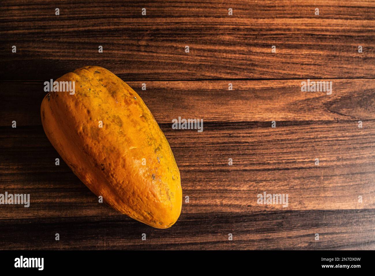 Eine frische reife organische Papaya auf einem Holztisch. Lebensmittelfotografie Stockfoto