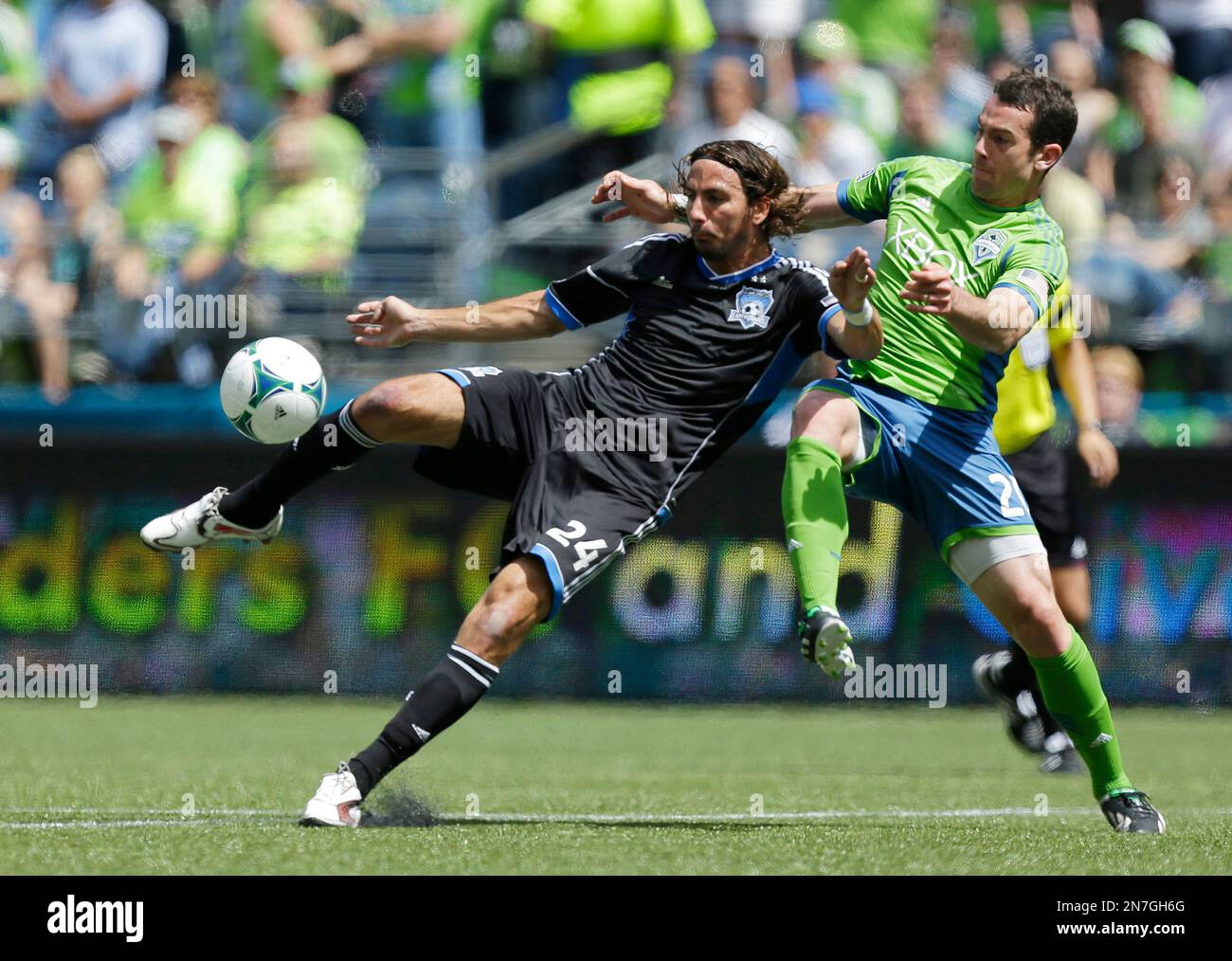 Seattle Sounders' Zach Scott, right, moves in to defend as San Jose Earthquakes' Alan Gordon (24) attempts a shot in the first half of an MLS soccer match, Saturday, May 11, 2013, in Seattle. (AP Photo/Ted S. Warren) Stockfoto