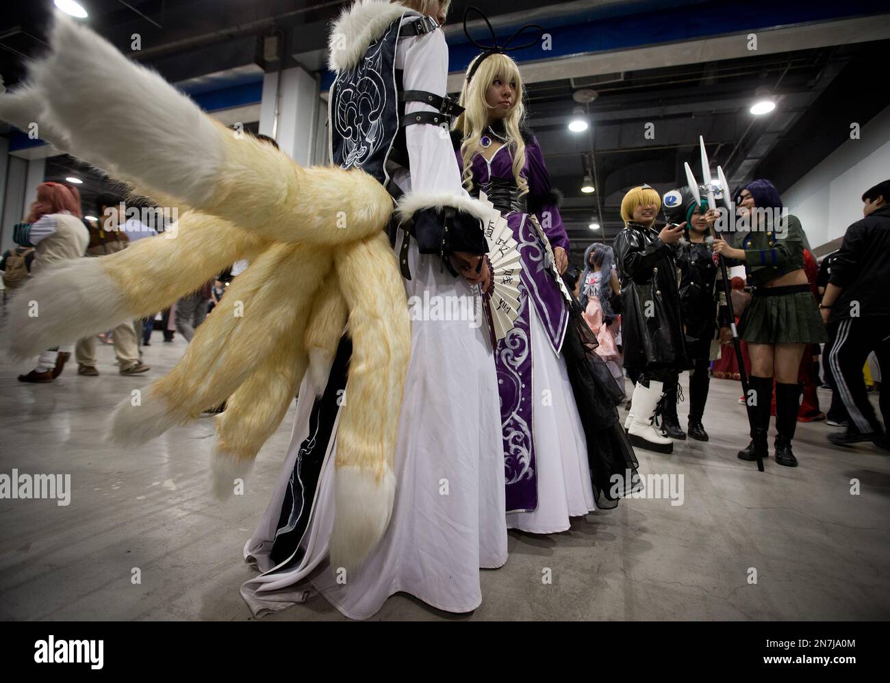 Chinese cosplay enthusiasts dressed as cartoon characters pose for photographs for visitors at the China Joy Animation and Comics Fair in Beijing, China Wednesday, May 1, 2013. Cosplay, from the term costume play, involves participants dressing up as their favorite animated characters. (AP Photo/Andy Wong) Stockfoto
