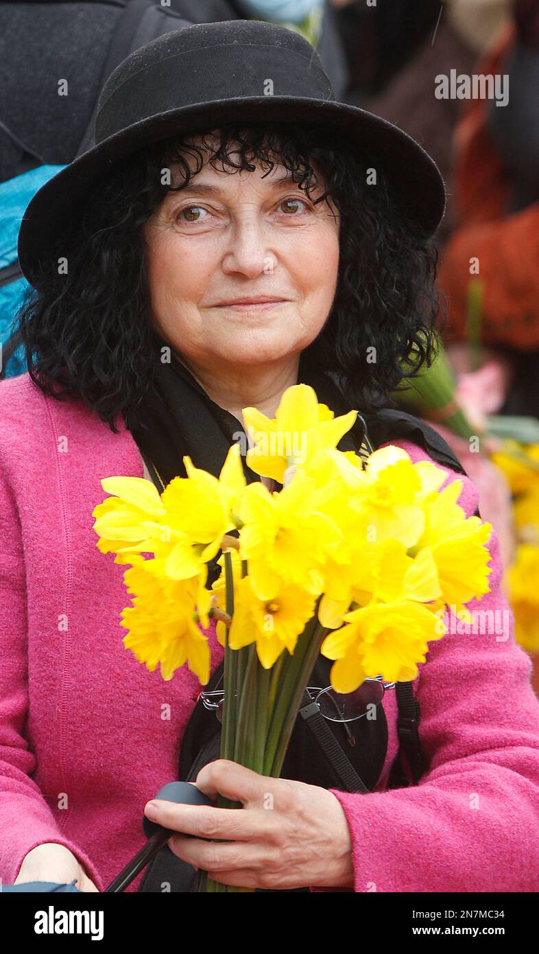 A woman holds flowers at the Warsaw Ghetto Uprising memorial during ceremonies marking the 70th anniversary of the outbreak of the revolt, in Warsaw, Poland, Friday, April 19, 2013. (AP Photo/Czarek Sokolowski) Stockfoto