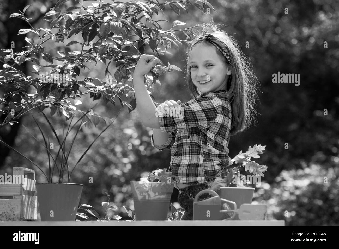 Mädchen-Macht. Porträt eines Kindergärtners, der auf dem Bauernhof geerntet wird. Glücklicher kleiner Bauer, der Spaß auf dem Feld hat. Kleinkinder arbeiten im Blumenpark. Stockfoto