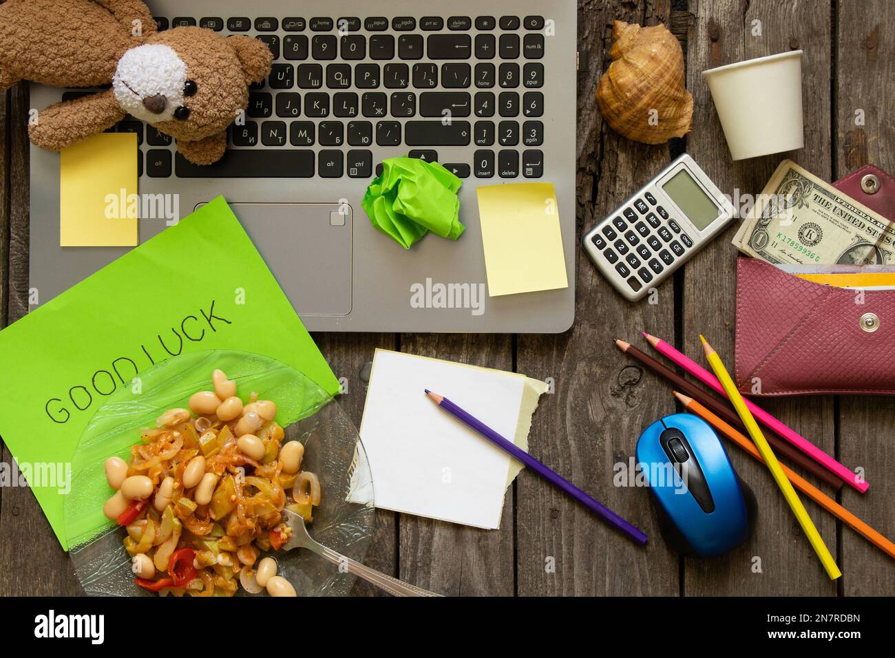 Auf dem Desktop-Laptop-Bleistifte und Geldpapier und Essenswortttteller im englischen Glück Stockfoto