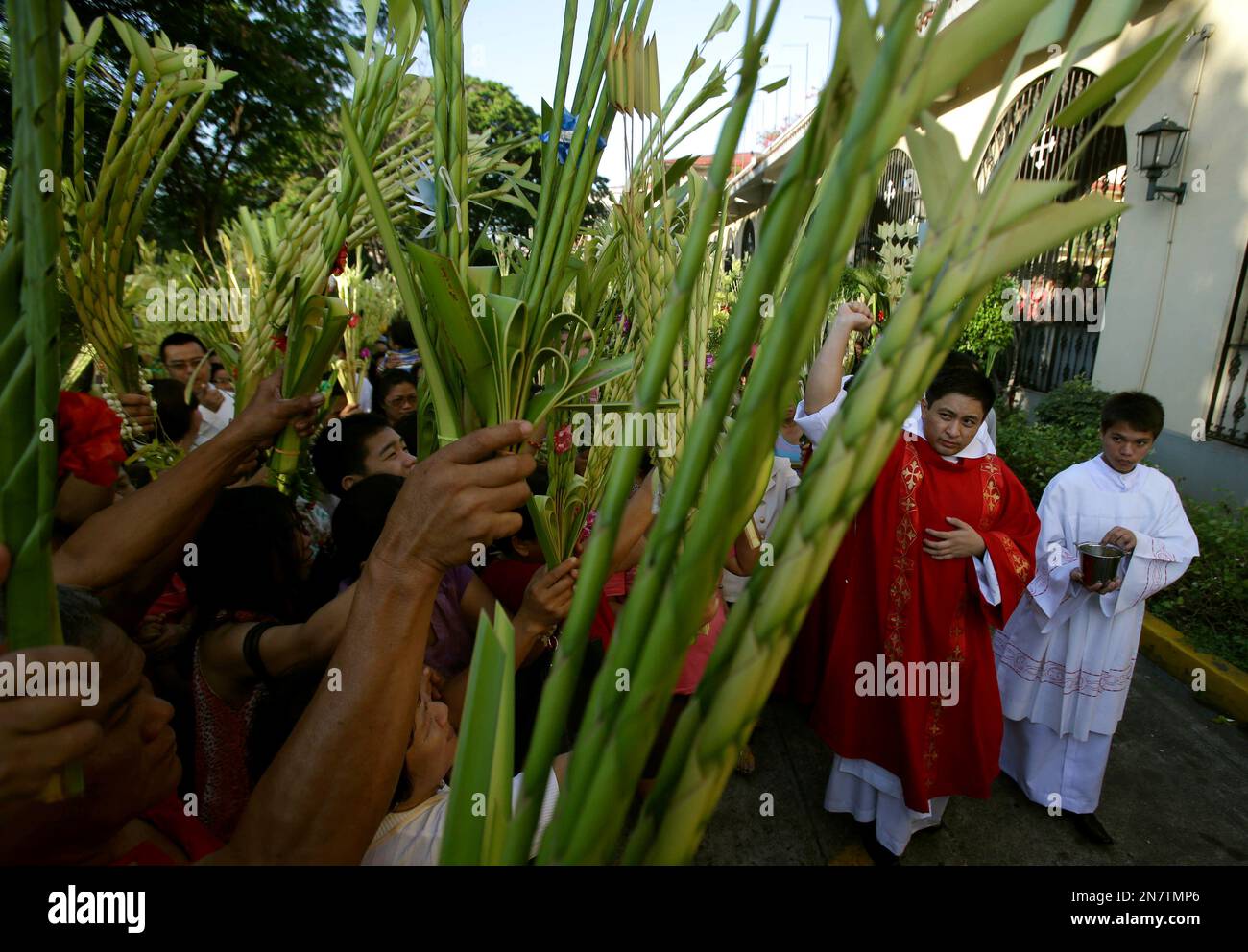 A Filipino Catholic priest blesses palm fronds outside the Santo Domingo Church in suburban Quezon city, north of Manila, Philippines during Palm Sunday rites on Sunday, March 24, 2013. Roman Catholics across the country observed Palm Sunday to signify the entry of Jesus Christ into Jerusalem and to usher in the start of Holy Week. (AP Photo/Aaron Favila) Stockfoto