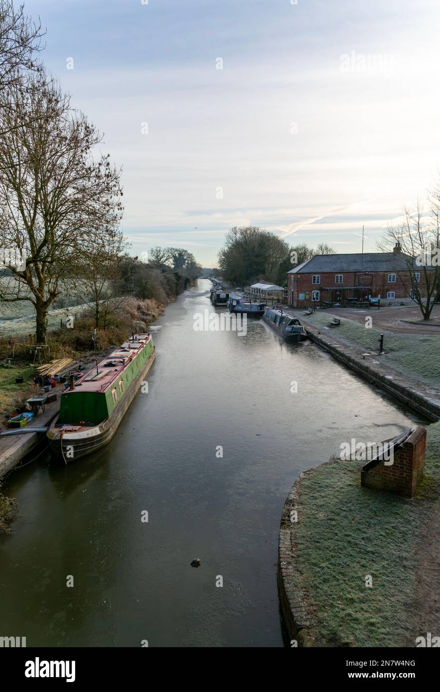 Schmale Boote auf gefrorenem Wasser von Kennet und Avon Canal, Pewsey Wharf, Wiltshire, England, Großbritannien Stockfoto