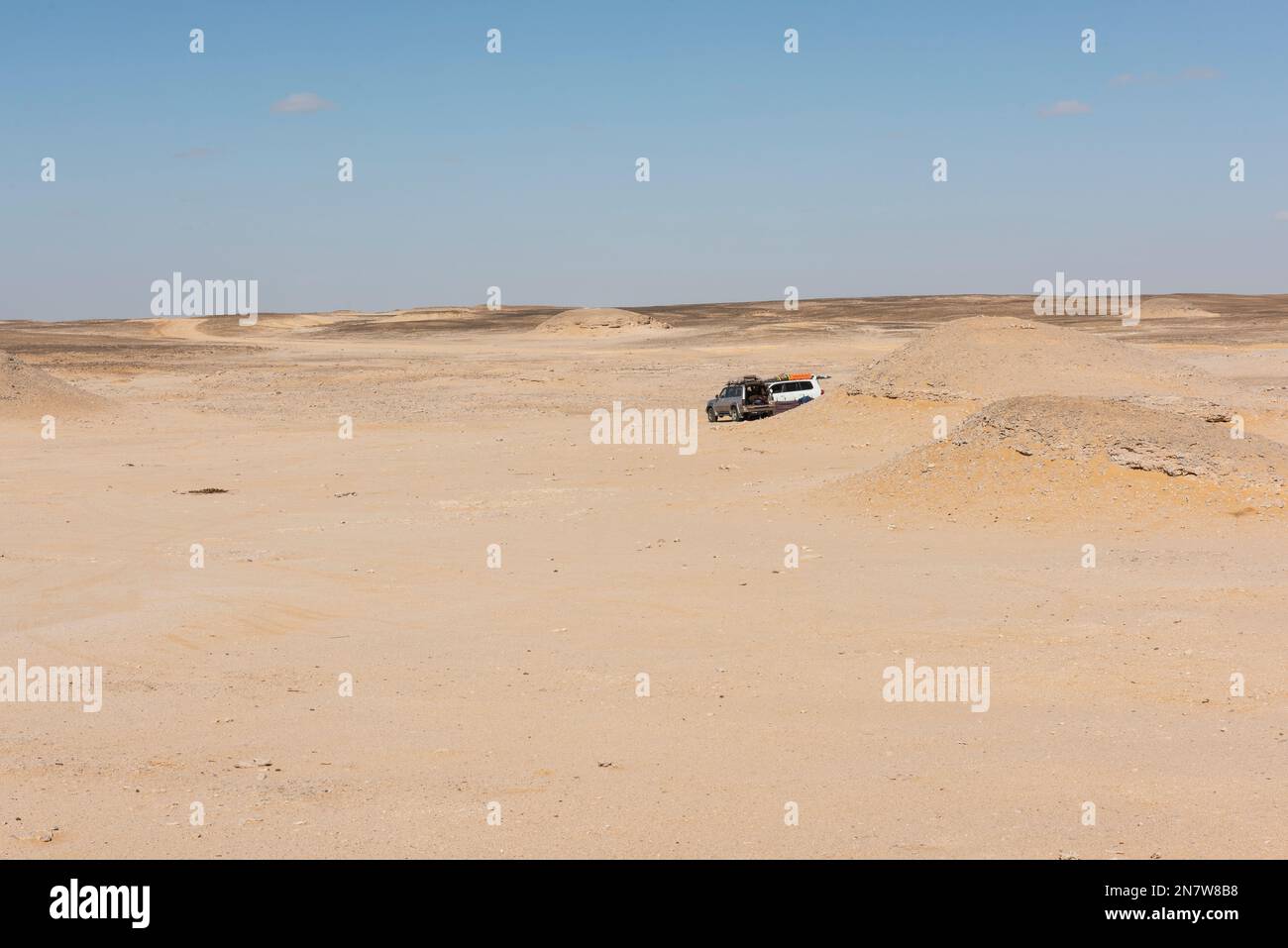 Malerischer Landschaftsblick auf die einsame, karge Wüste im Westen Ägyptens mit felsigem ausblick und Geländewagen Stockfoto