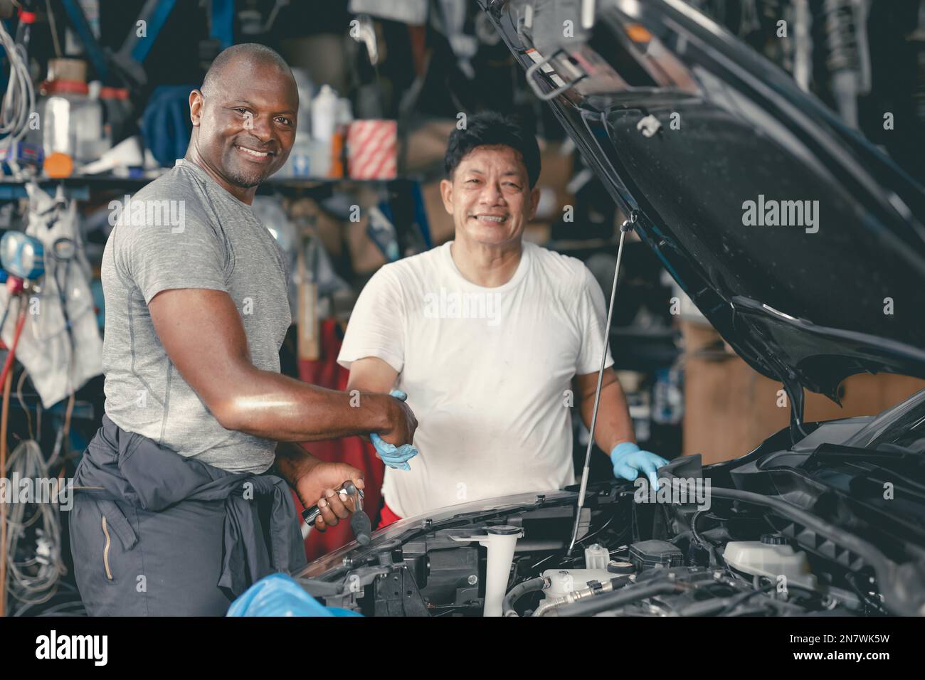 Werkstattmechaniker, die Hand schütteln, um gemeinsam Auto-Service zu betreiben Stockfoto