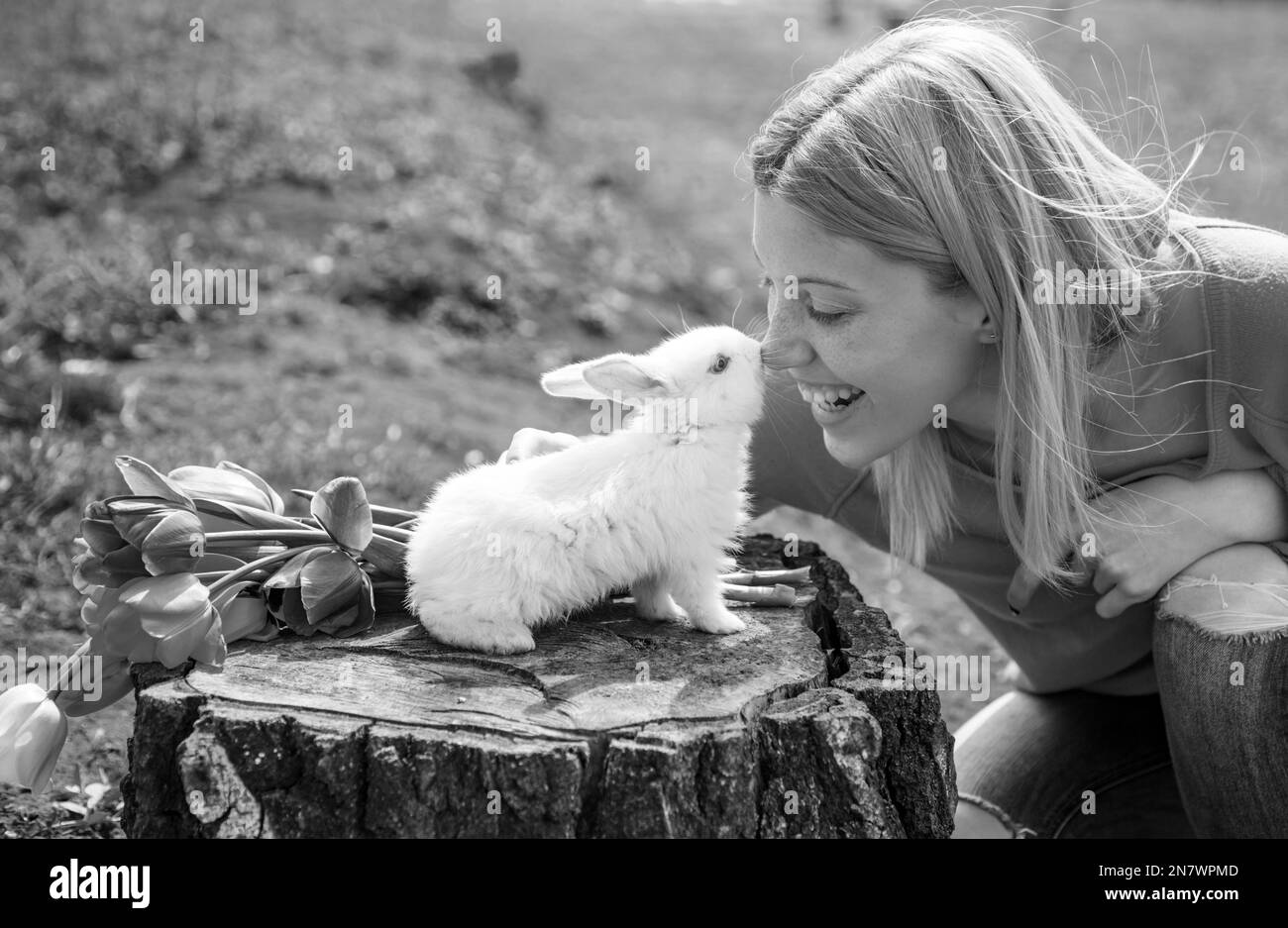 Alice im Wunderland. Osterhase. Schöne Frau halten weißen Kaninchen. Frohe Ostern. Stockfoto