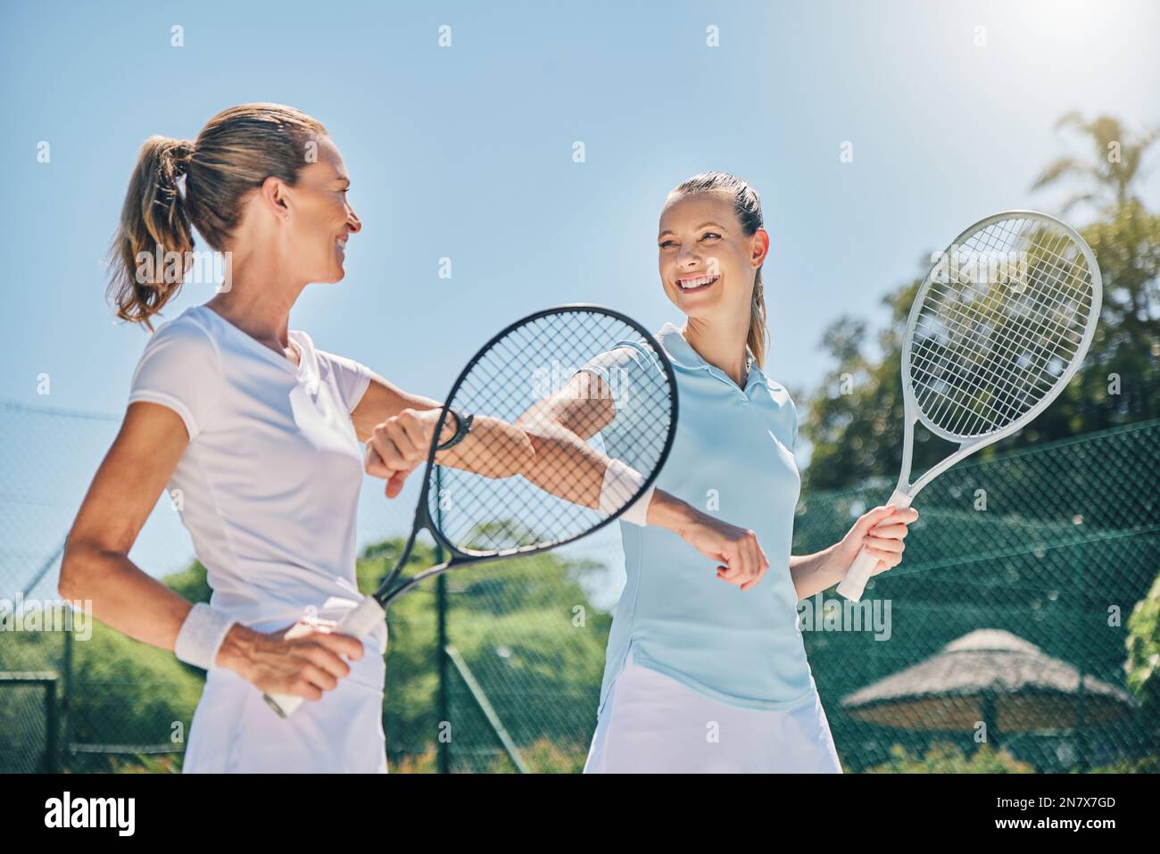 Tennis, Frauen und sportlicher Ellbogen begrüßen draußen auf dem Platz für Fitness und Training für Wettkämpfe. Fröhliche Freundinnen im Club für das Spiel Stockfoto