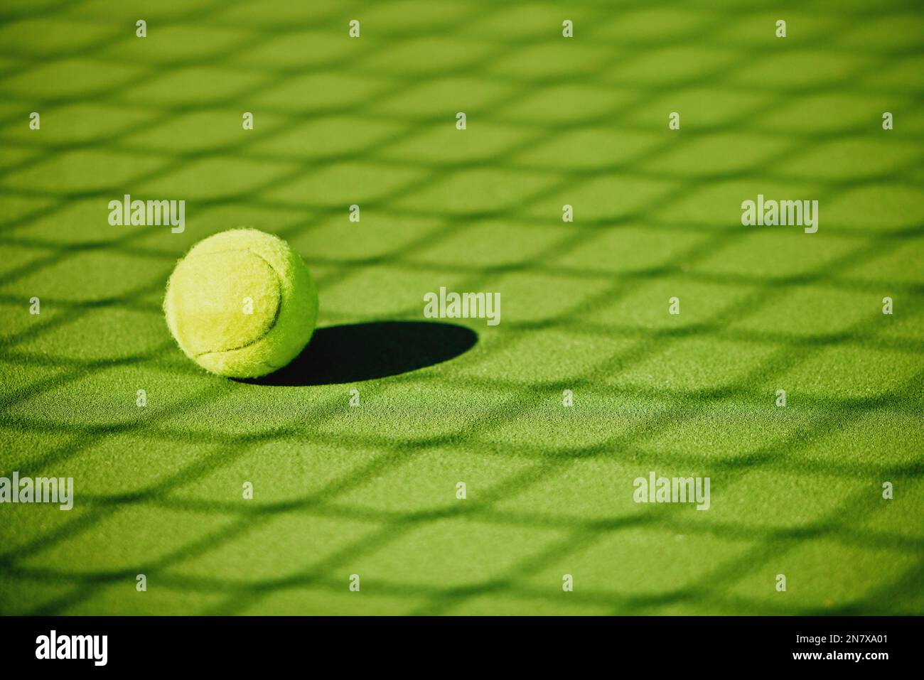 Tennisball, Hofschatten und grüne Konsistenz von Rasenspielen ohne Menschen. Sport, leerer Sporttrainingsplatz und Rasenobjektzoom von Schatten für Stockfoto
