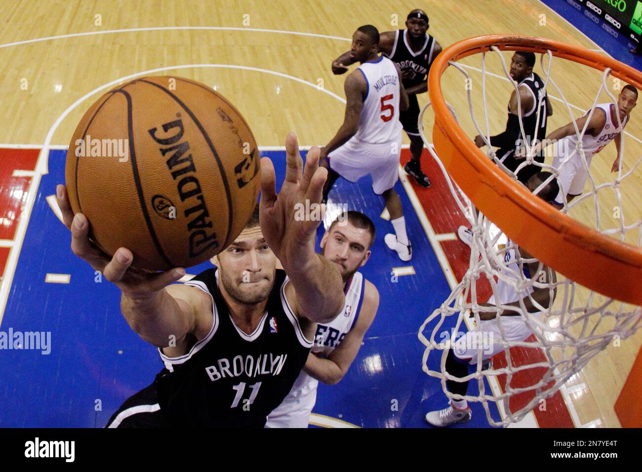 Brooklyn Nets' Brook Lopez, left, shoots as Philadelphia 76ers' Spencer Hawes defends in the first half of an NBA basketball game, Monday, March 11, 2013, in Philadelphia. (AP Photo/Matt Slocum) Stockfoto