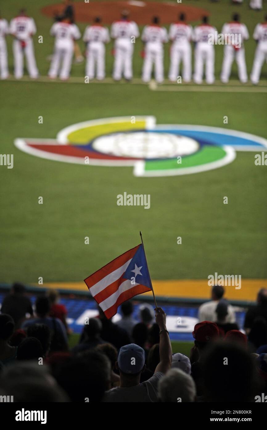 A baseball fan waves a Puerto Rican flag before the start of the World