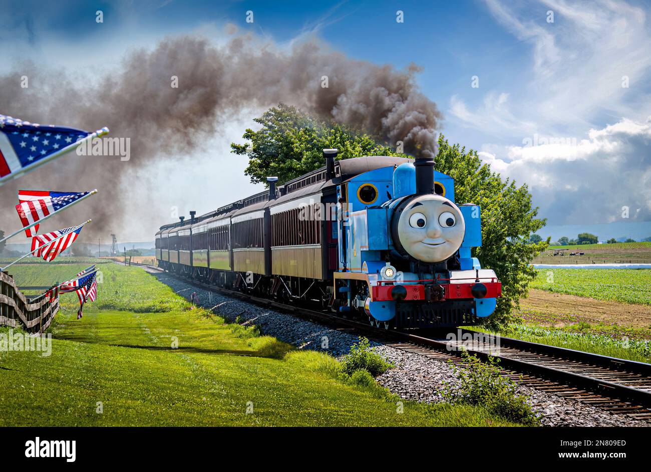 Strasburg, Pennsylvania. Juni 18 2021 - Blick auf Thomas, den Zug, der an einem sonnigen Tag an amerikanischen Flaggen vorbeifährt und dabei Passagierwagen zieht Stockfoto