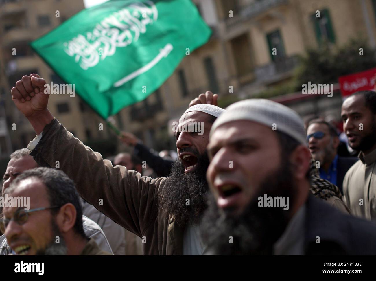 Egyptian Salafi Muslims chant slogans during a protest in support of bearded police officers who were prevented from carrying out their work in the interior ministry, in front of Abdeen presidential palace in downtown Cairo, Egypt, Friday, March 1, 2013. The Arabic writing on the green flag waving in the back reads, "No god but Allah and Muhammed is the prophet."(AP Photo/Khalil Hamra) Stockfoto