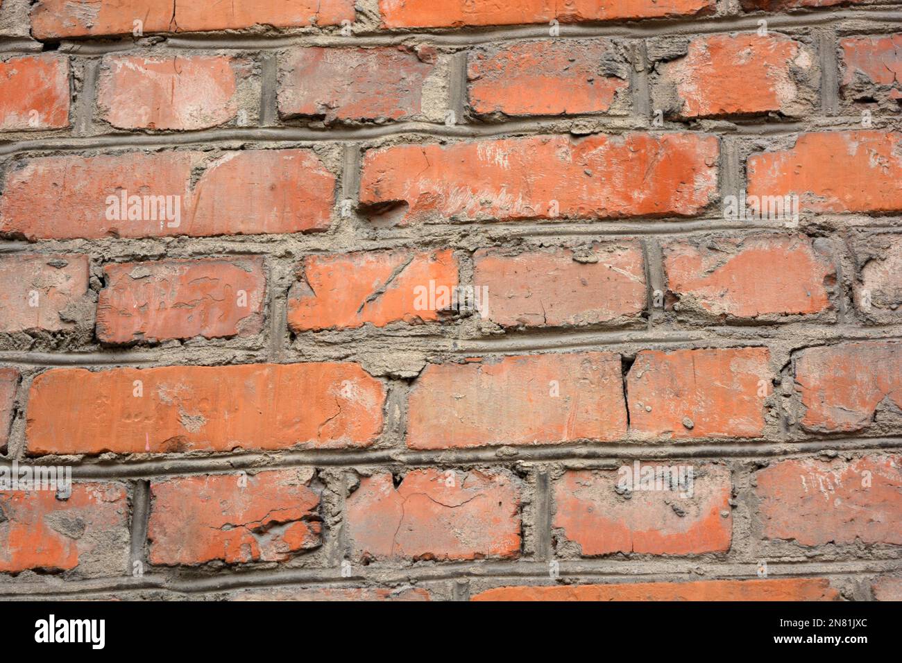 Die Gebäudewand eines der Häuser ist aus altem, massivem rotem Kirpech und zuverlässigem Zementmauerwerk errichtet. Stockfoto