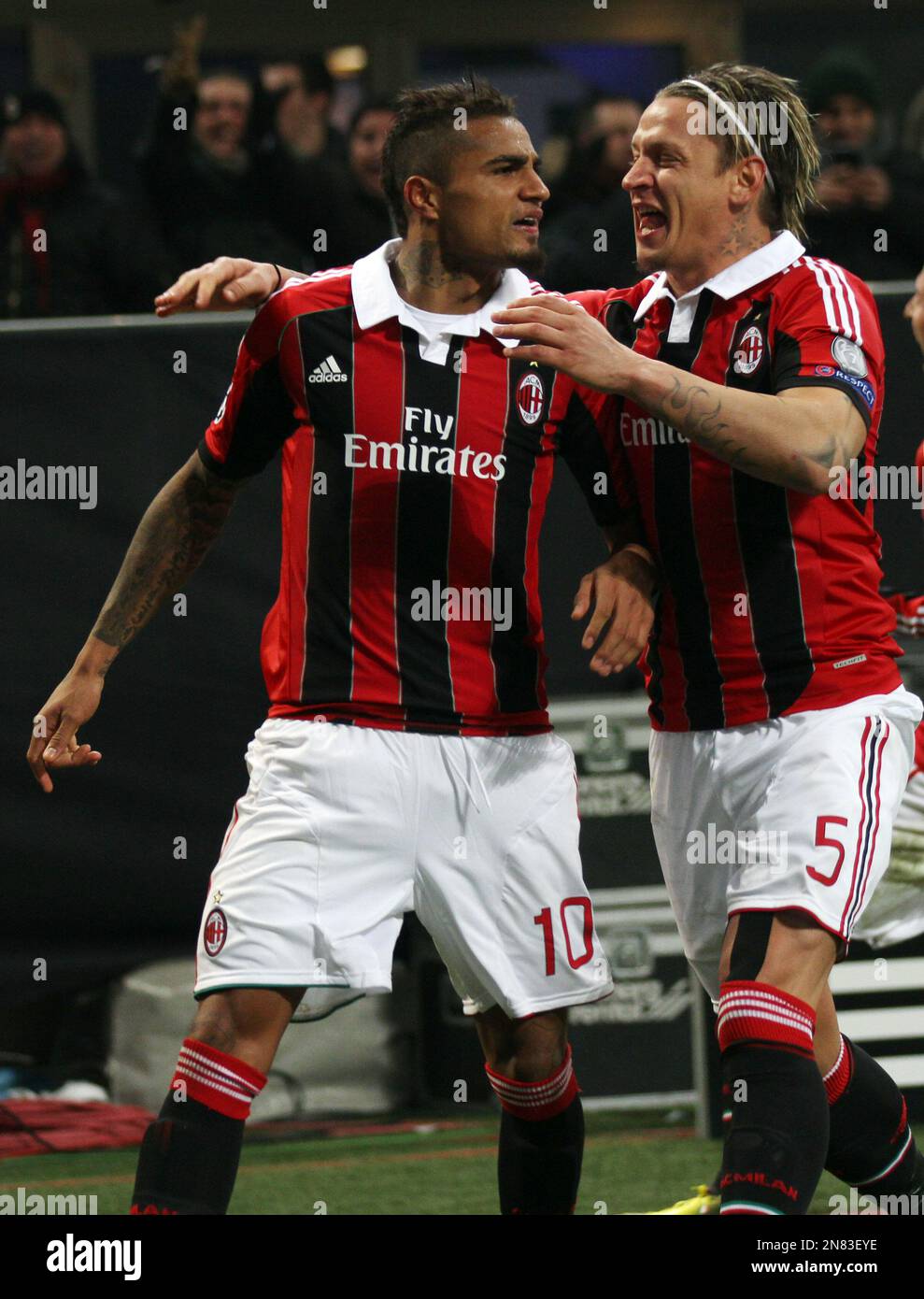 AC Milan's Kevin-Prince Boateng, left, celebrates with teammate Philippe Mexes, of France, after scoring during theirChampions League round of 16, first leg soccer match, at the San Siro stadium in Milan, Italy, Wednesday, Feb. 20, 2013. (AP Photo/Felice Calabro') Stockfoto