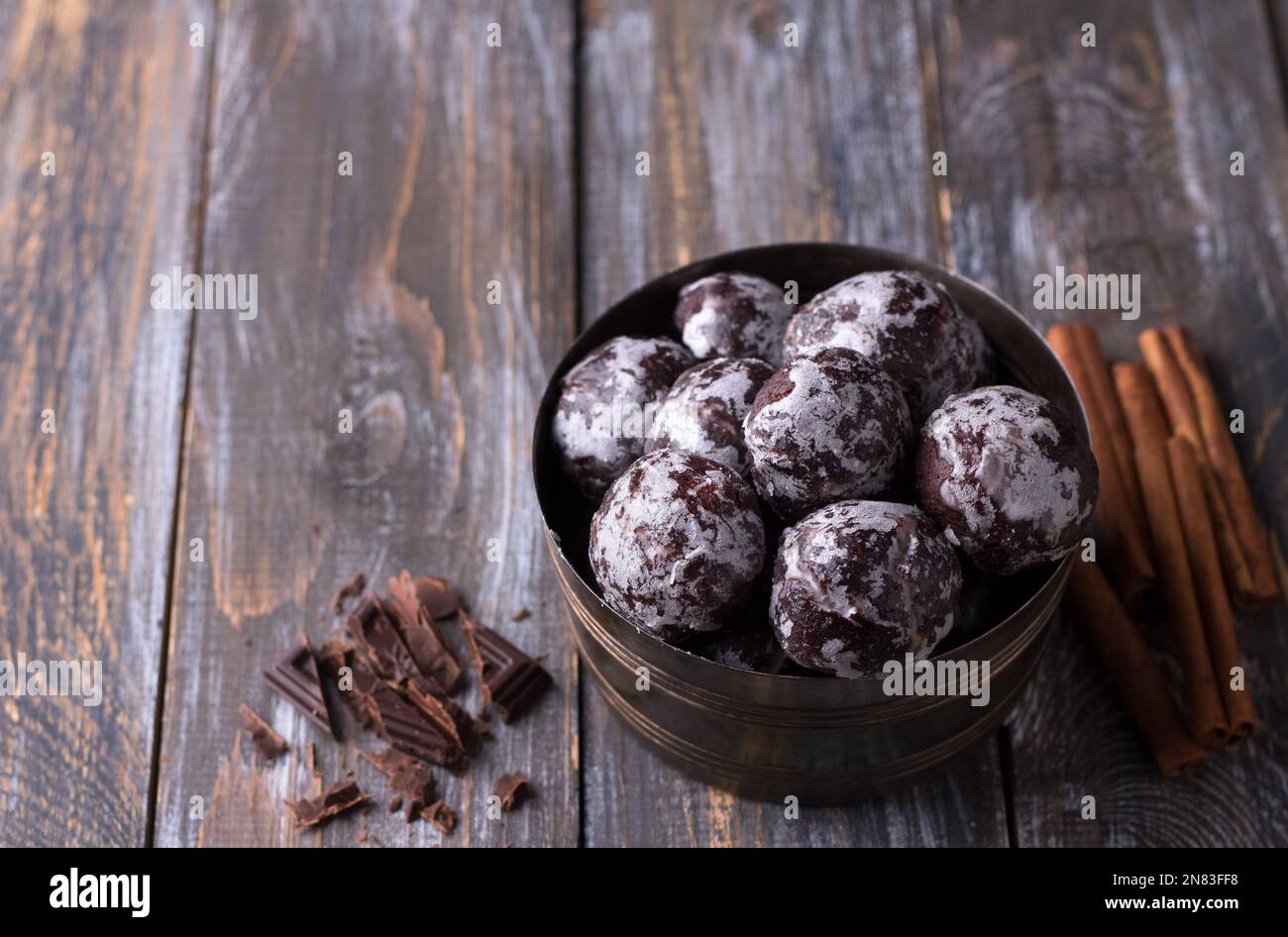 Weiche vegane, gedämpfte Schokoladen-Lebkuchen mit Puderzucker in einer alten Schüssel auf einem Holztisch, freier Platz Stockfoto