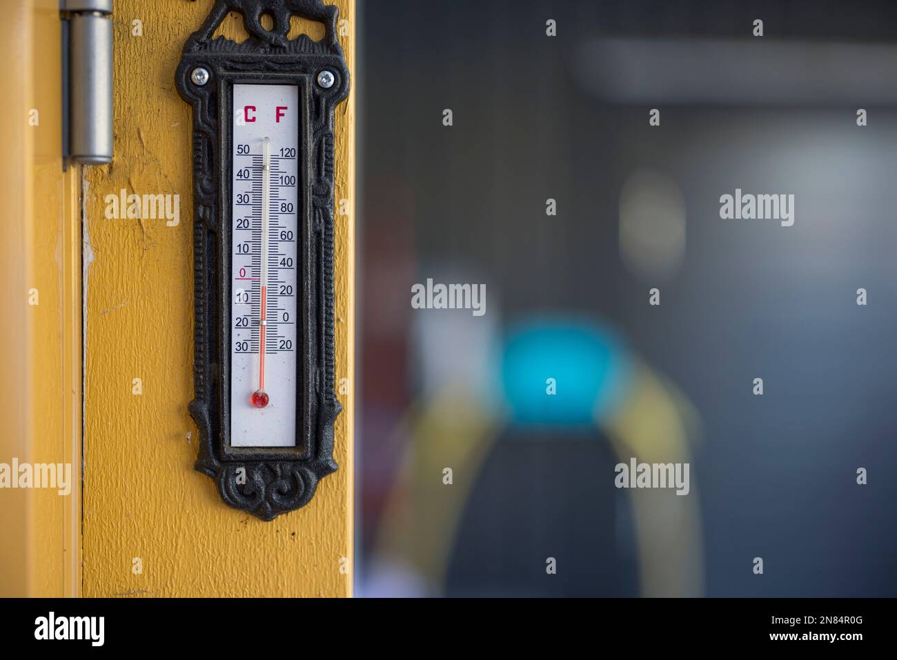 Blick auf das Außenthermometer an der gelben Holzsäule im Winter. Schweden. Stockfoto