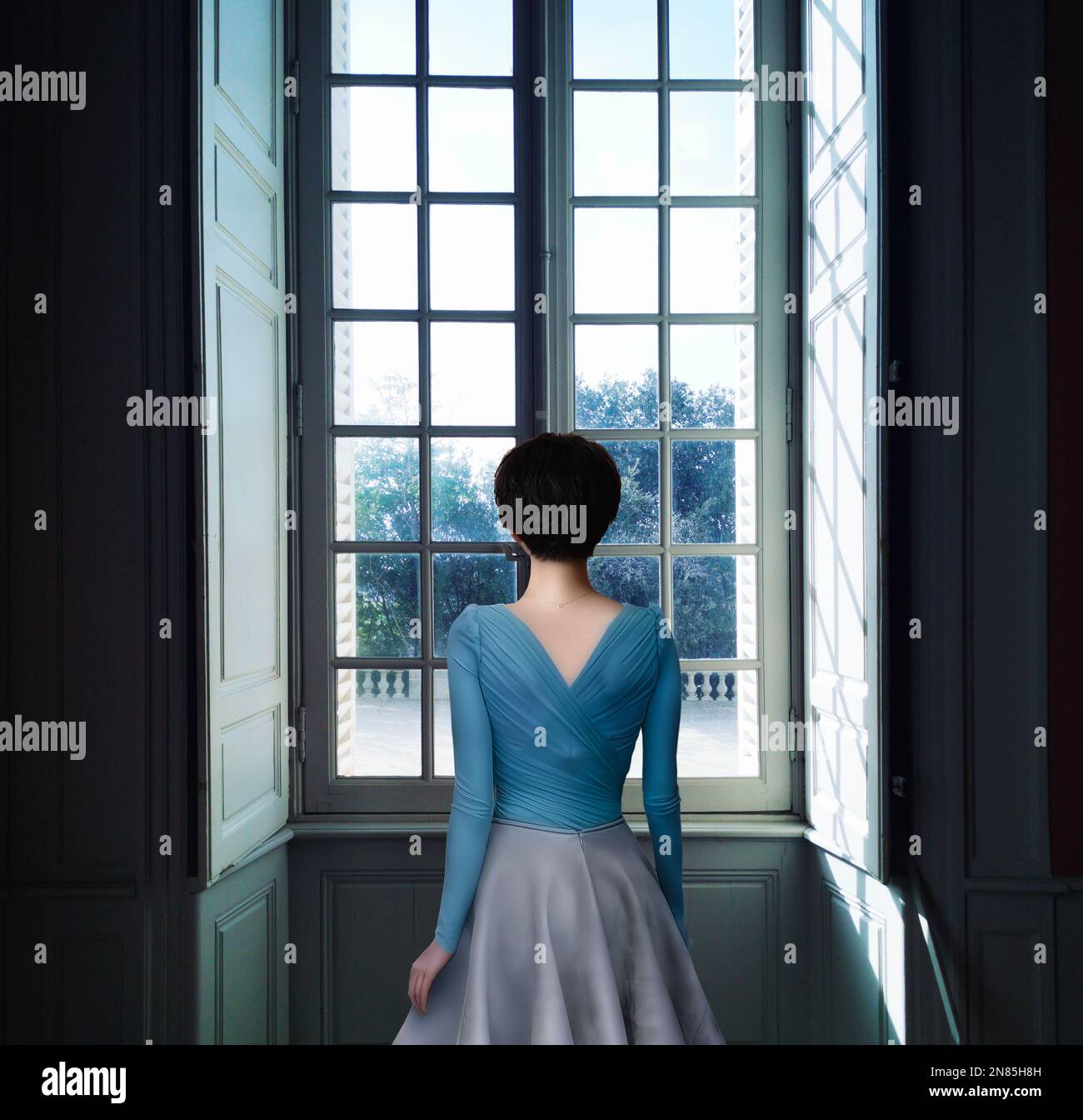 Frau, die durch Fenster Stockfoto