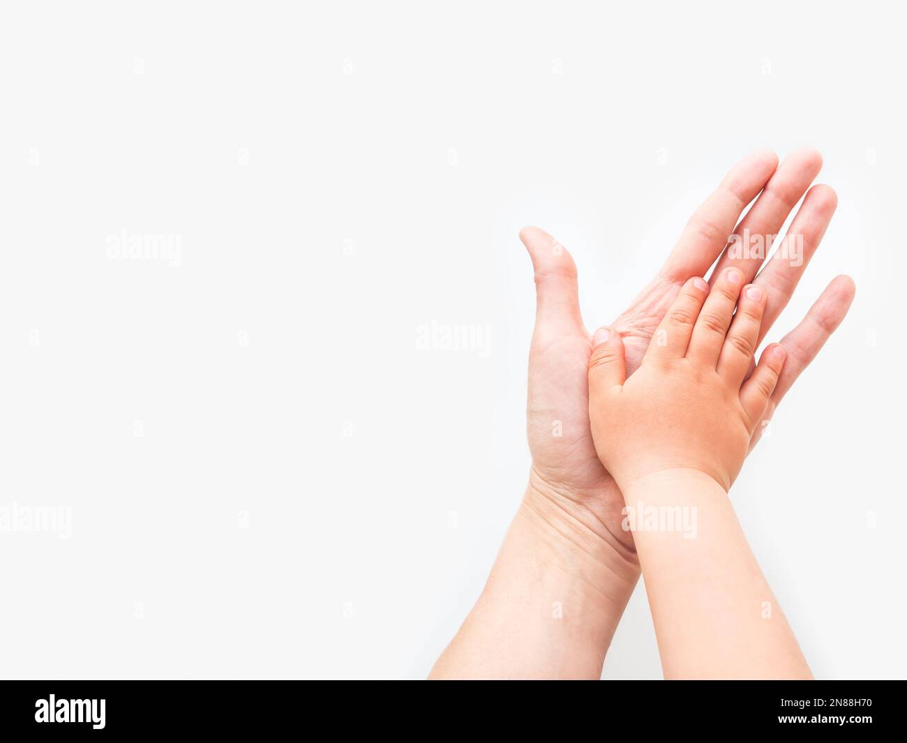 Hände von Erwachsenen und Kindern. Mutter und Kind legten ihre Handflächen auf weißem Hintergrund zusammen. Eltern und Kleinkinder. Symbol der Familie, Einstimmigkeit, Unterstützung. Stockfoto