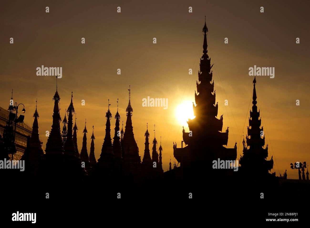 Silhouetten von Stupas der Shwedagon-Pagode bei Sonnenuntergang. Es ist Yangons berühmtestes Wahrzeichen und die heiligste buddhistische Pagode des Landes. Die Schläfe Stockfoto