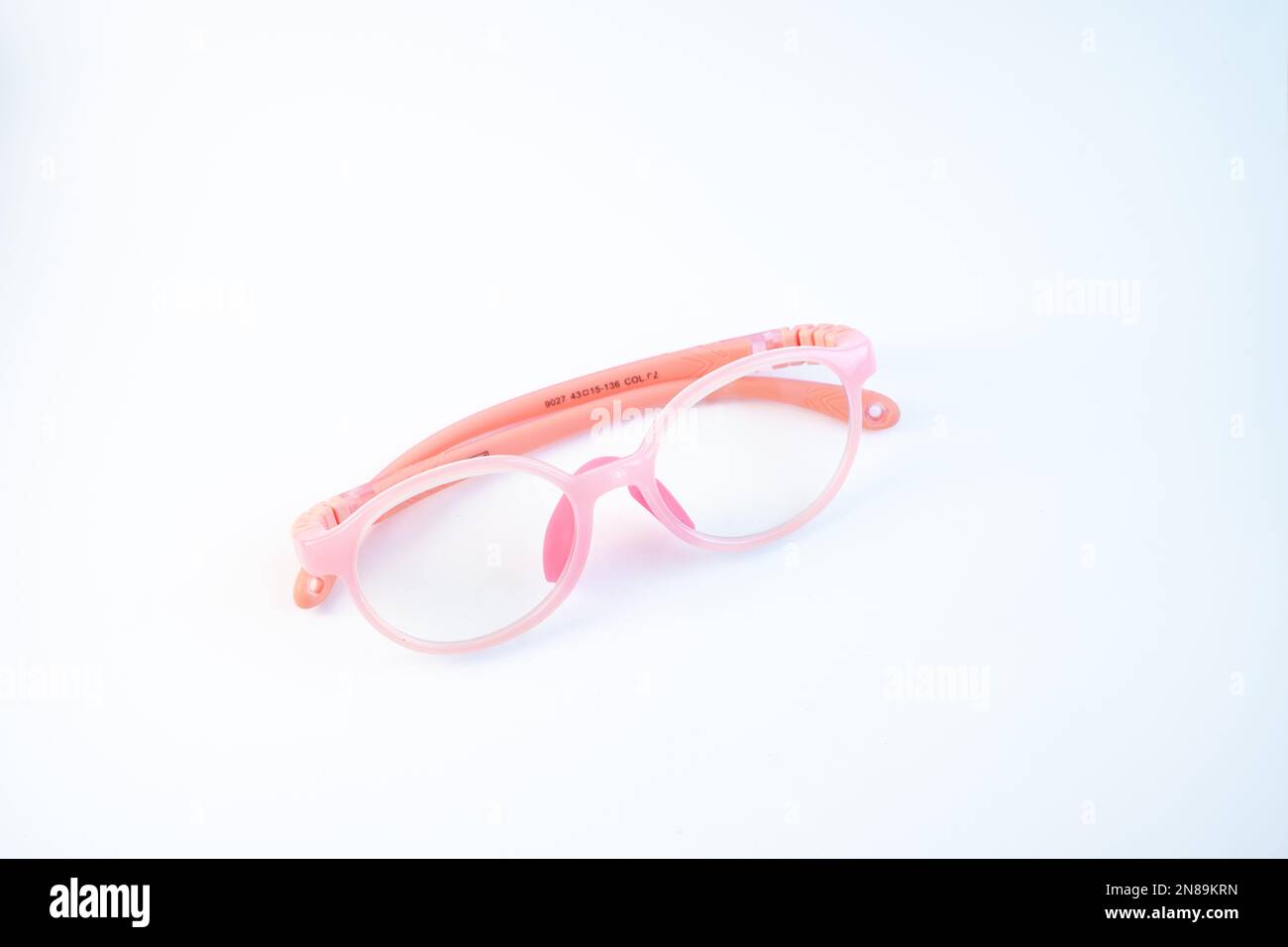 Blaue Lichtbrille für Kinder. Rosafarbene Brille auf weißem Hintergrund, Draufsicht Stockfoto