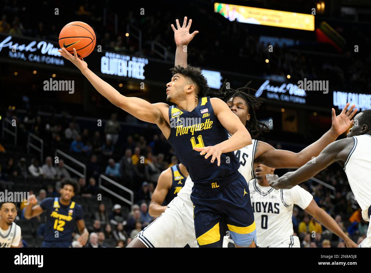 Marquette guard Stevie Mitchell (4) shoots past Georgetown forward ...