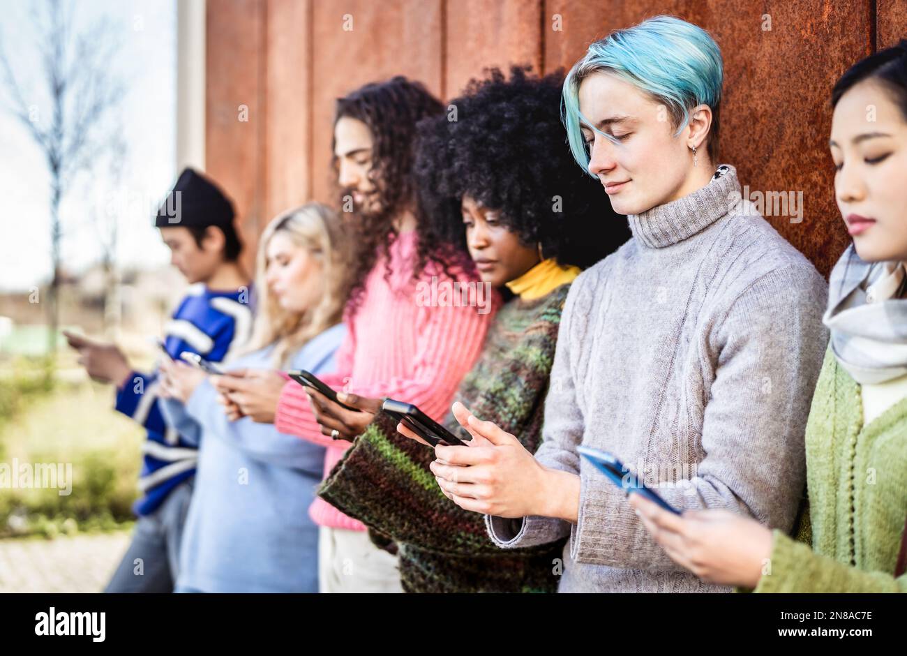 Verschiedene Personengruppen, die auf dem Campus der Universität ein Smartphone verwenden - Junge abhängige Freunde, die Inhalte auf einem Smartphone teilen - Tech Life Style CO Stockfoto