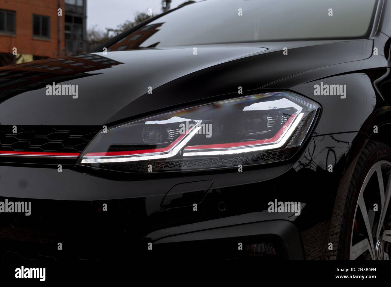 Der vordere LEDXenonScheinwerfer mit rotem GTINadelstreifen Eines 2020 Volkswagen Golf GTI