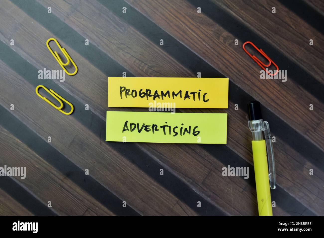 Konzept der programmatischen Werbeschrift auf Haftnotizen isoliert auf Holztisch. Stockfoto