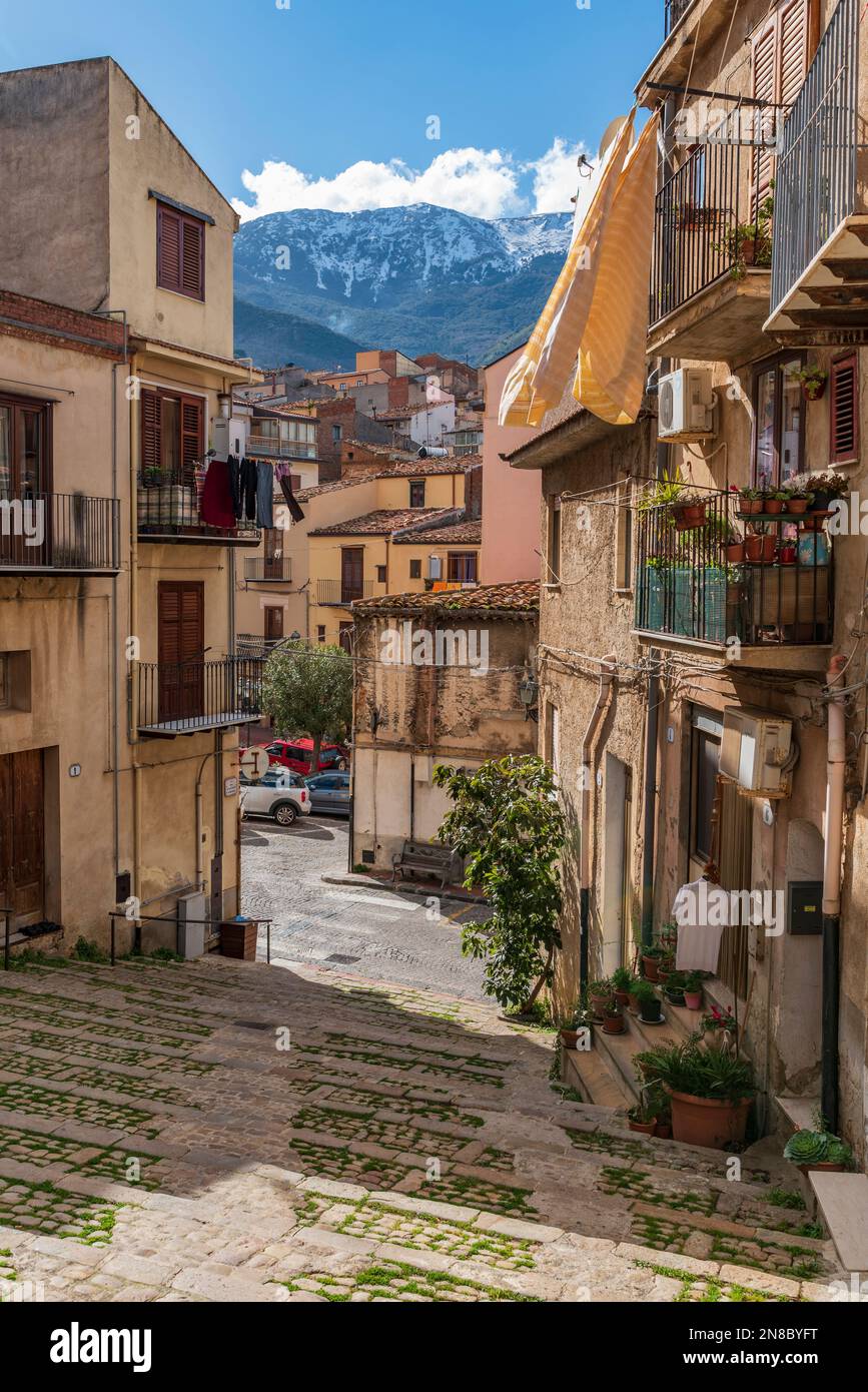 Eine Gasse des Dorfes Castelbuono mit den schneebedeckten Gipfeln der Madonie vor Sizilien Stockfoto