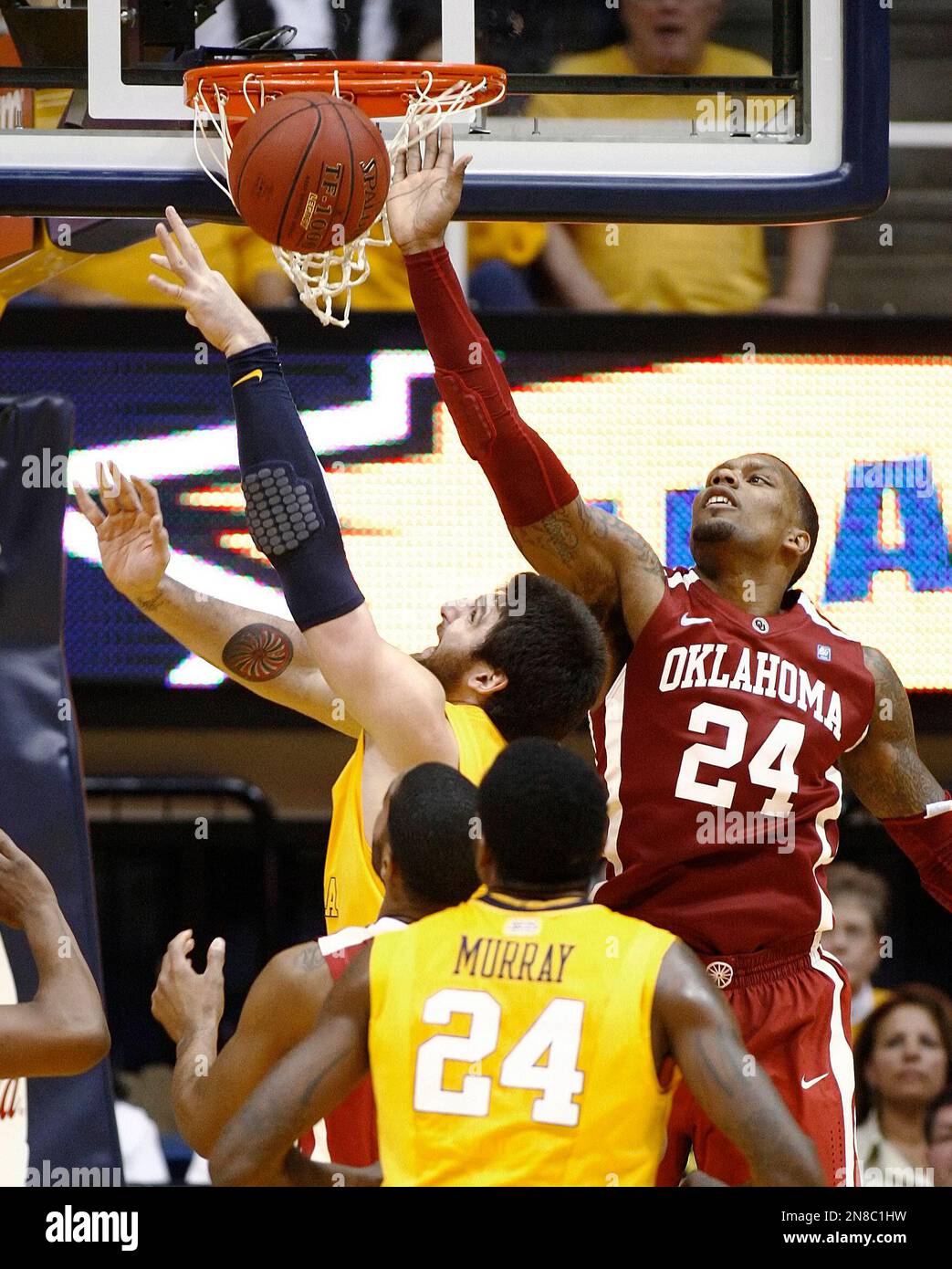 Oklahoma's Romero Osby, right, blocks a shot by West Virginia's Deniz