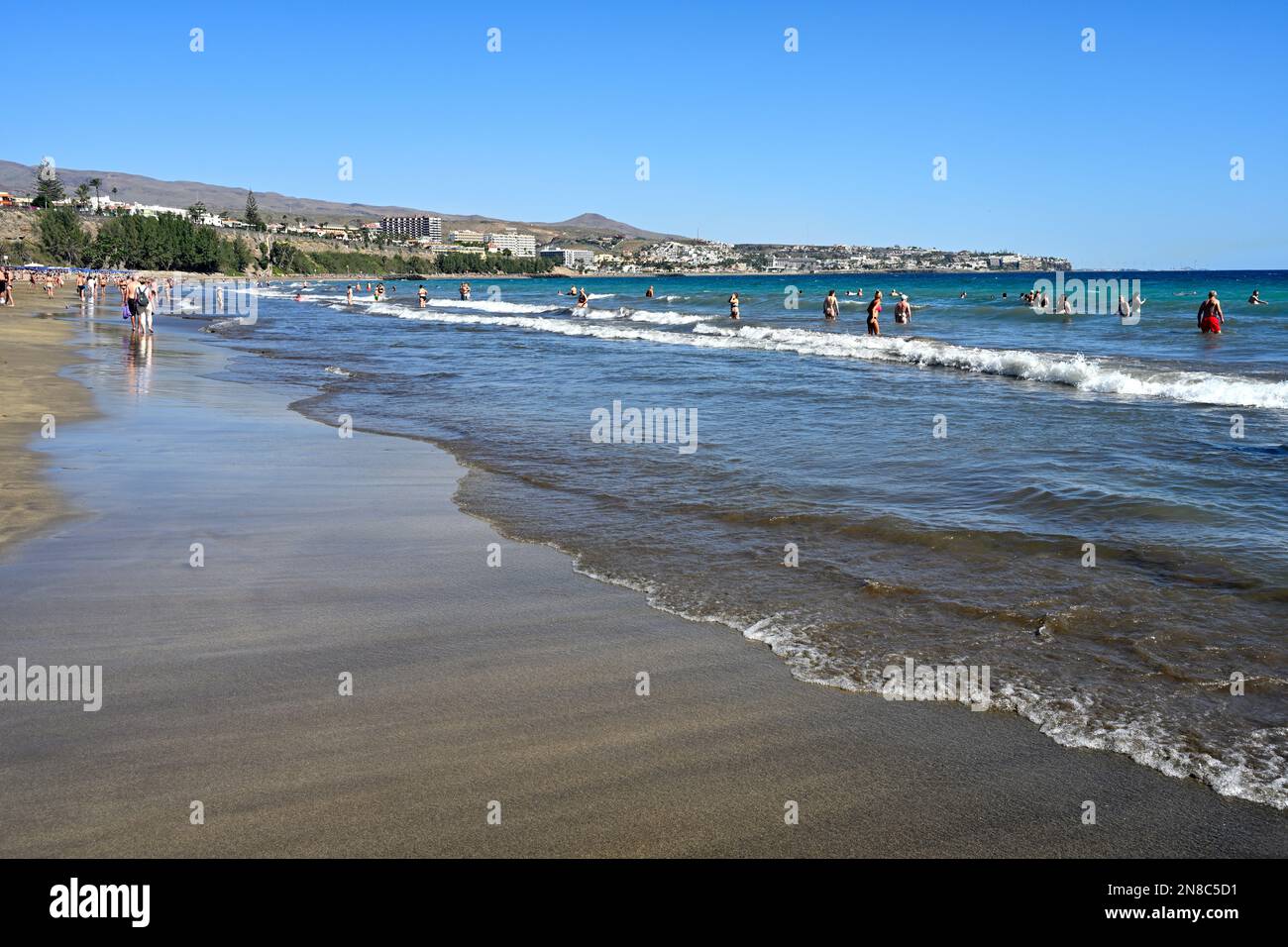 Am Sandstrand Playa del Inglés mit Menschen im Meer, Maspalomas, grenzt das Wasser an Stockfoto