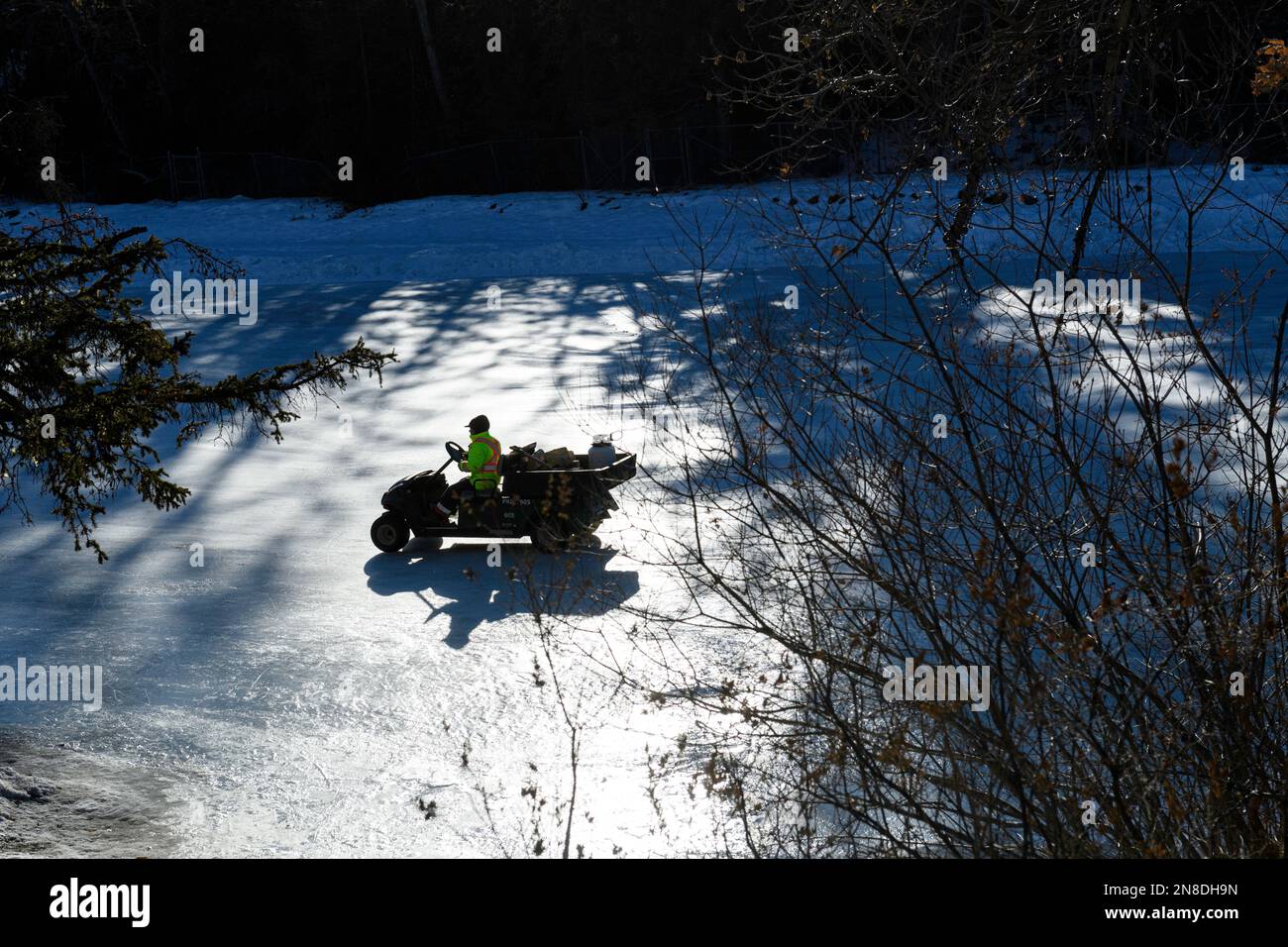 Instandhaltungstechniker von Stadtparks, die den Eislaufteich im Bowness Park, Calgary, Alberta, Kanada, im Freien wiederbeleben Stockfoto