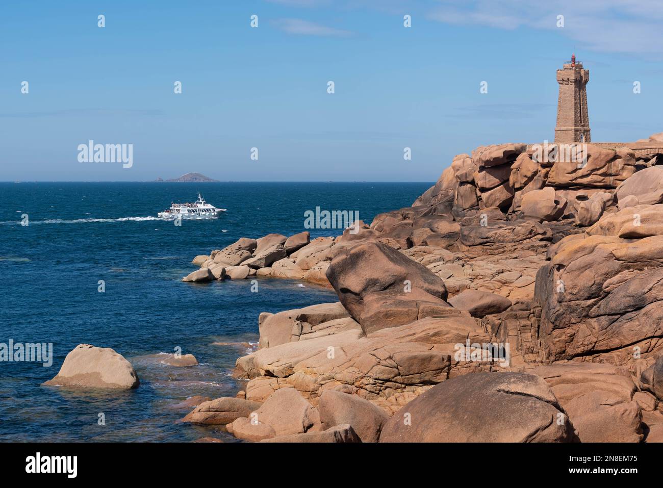 Ploumanac’h, Cotes d'Armor, Bretagne, Frankreich - 2. Juni 2022 : Kreuzfahrtschiff zu den sieben Inseln im Hintergrund und zum Leuchtturm Mean Ruz im for Stockfoto