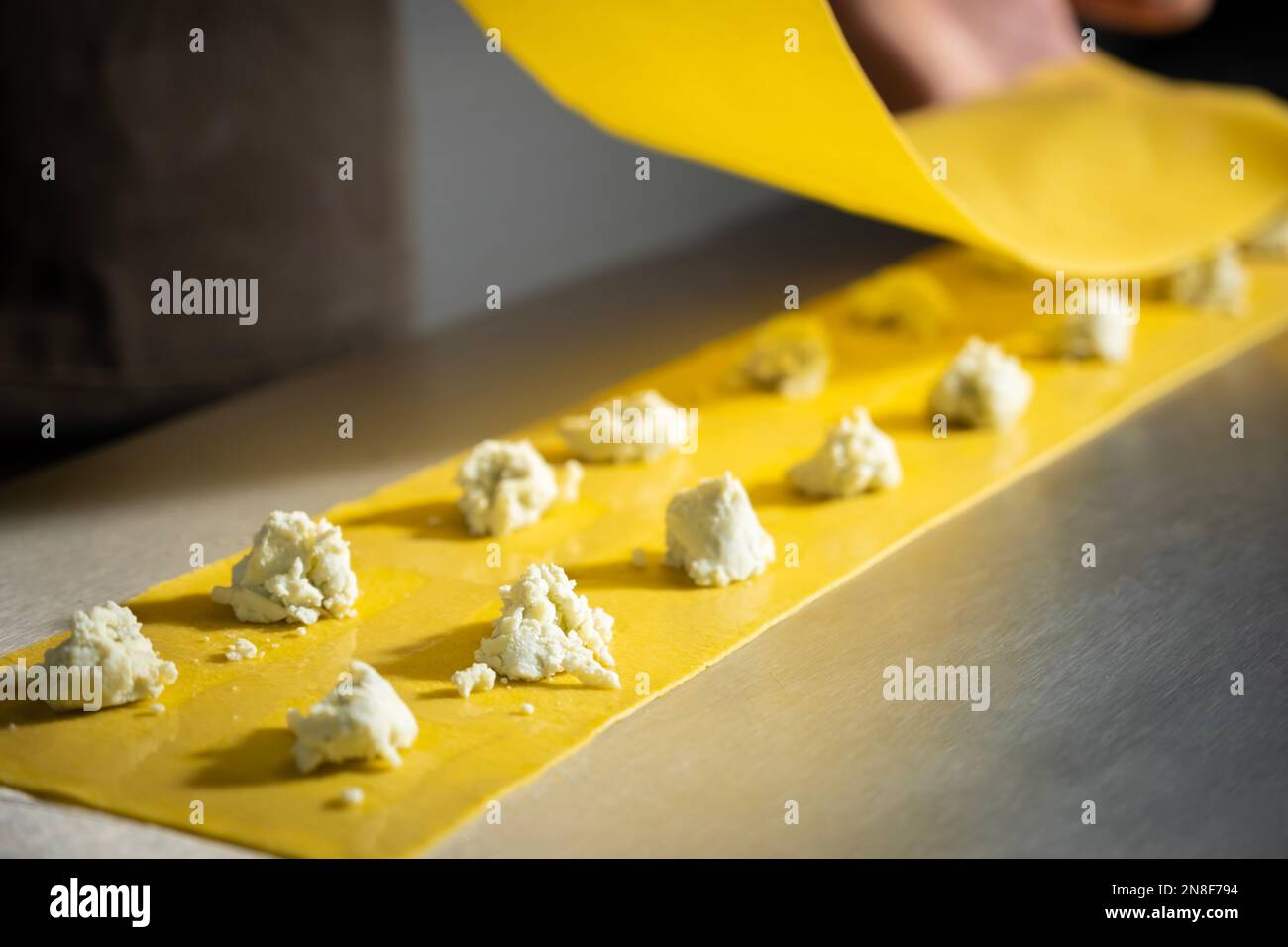 Zubereitung von frisch zubereiteten Ravioli mit Ricotta-Käse in einer Nudelfabrik. Ich mache vier Käseravioli. Stockfoto