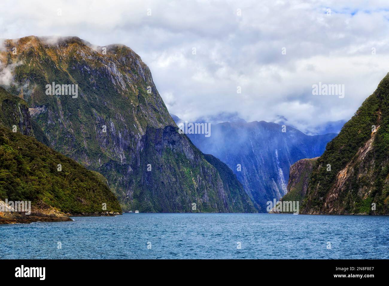 Steile Felsen von Berggipfeln rund um den Milford Sound Fjord der neuseeländischen Südinsel auf einer Bootstour. Stockfoto