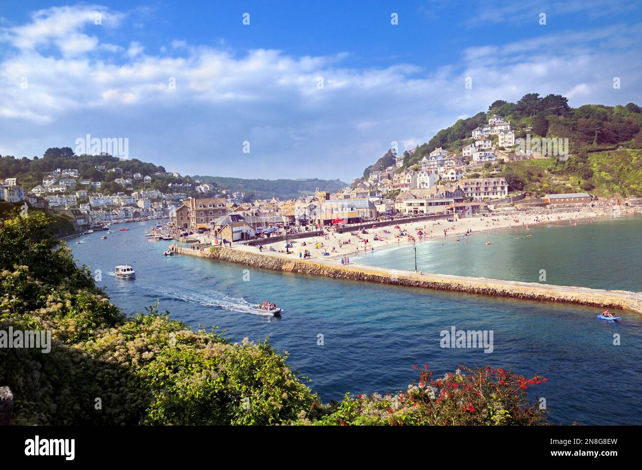 Ein erhöhter Blick auf Boote auf dem Fluss Looe mit Urlaubern, die Sommerwetter am Strand von East Looe, Looe, Cornwall, England, Großbritannien genießen Stockfoto