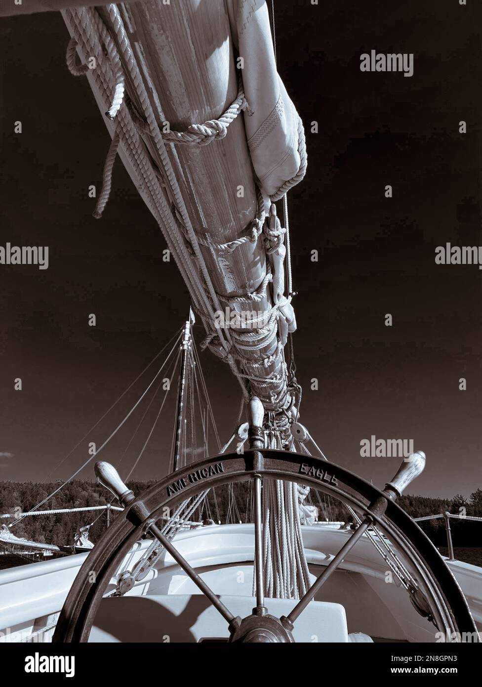 Foto in Sepiatönen eines alten Großseglers mit antikem Rad und gezacktem Großsegel Stockfoto